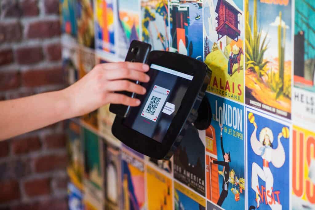 An arriving hotel guest uses a self-service kiosk for a contactless check-in.