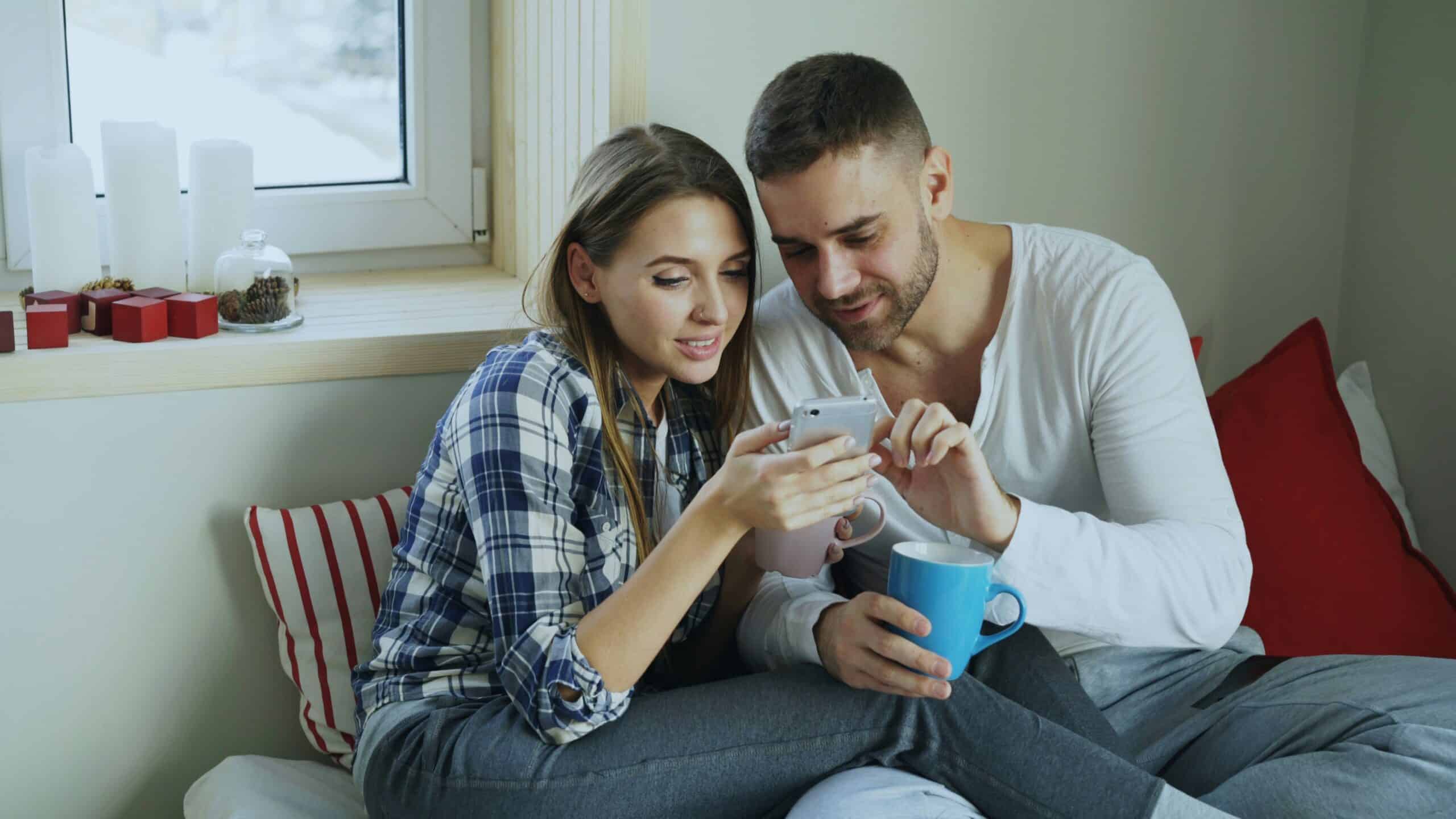 A pair of travelers use their mobile phone to research and book a trip in January.